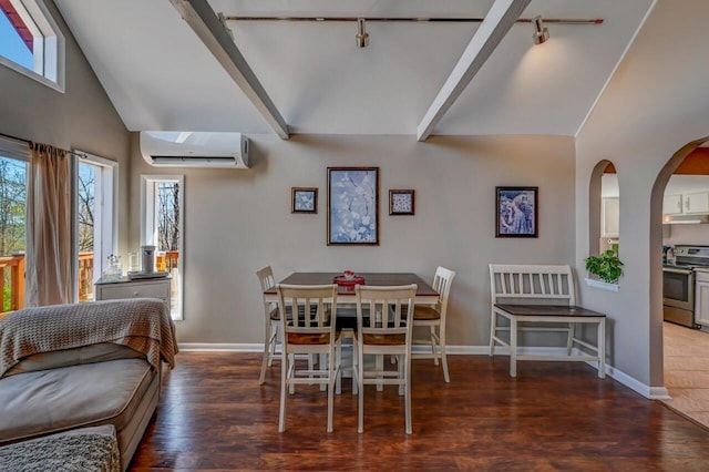 dining space featuring wood finished floors, baseboards, high vaulted ceiling, an AC wall unit, and rail lighting