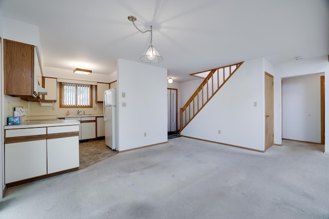 476 Hyland Dr, East Stroudsburg, PA 18301 - kitchen with hanging light fixtures, light carpet, a sink, light countertops, and freestanding refrigerator