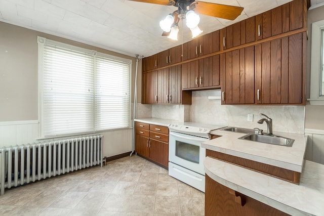 247 S 7th St, Lehighton, PA 18235 - kitchen featuring white range with electric stovetop, radiator heating unit, light countertops, ceiling fan, and tasteful backsplash