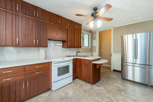 247 S 7th St, Lehighton, PA 18235 - kitchen with freestanding refrigerator, white range with electric stovetop, a ceiling fan, a peninsula, and light countertops