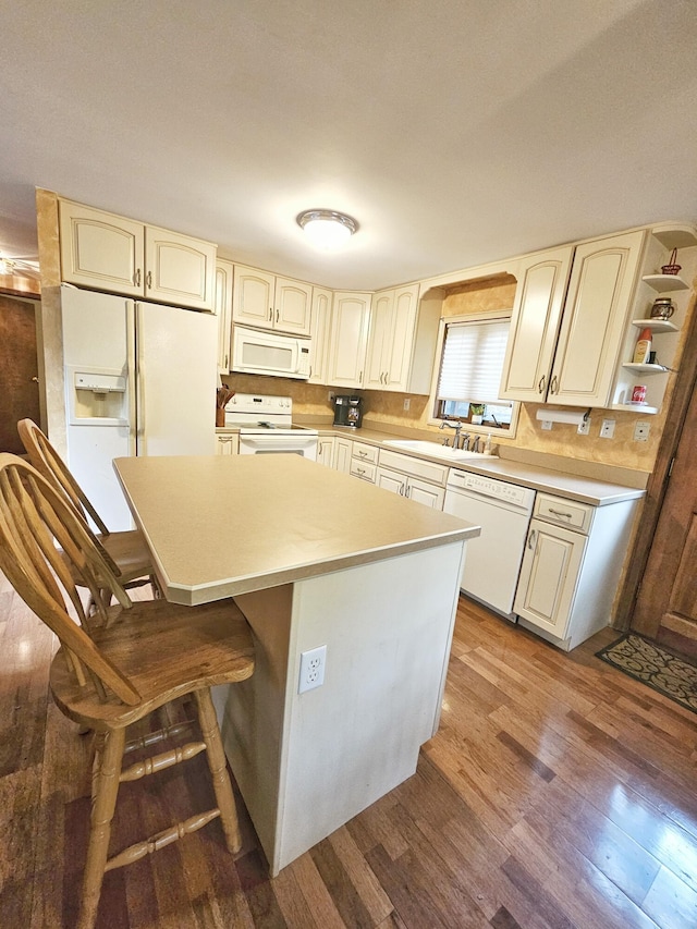 5081 Woodbridge Dr E, Bushkill, PA 18324 - kitchen with white appliances, wood finished floors, a center island, and cream cabinets
