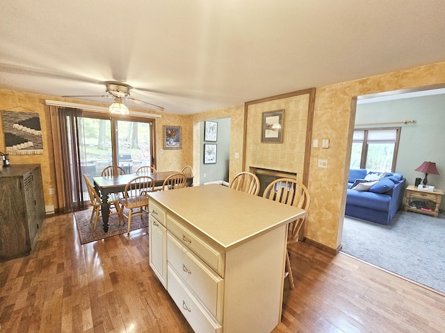 5081 Woodbridge Dr E, Bushkill, PA 18324 - kitchen featuring a tile fireplace, wood finished floors, a breakfast bar area, and a kitchen island
