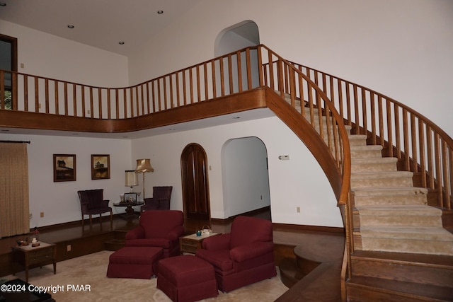 6760 Bear Creek Blvd, Bear Creek Township, PA 18702 - living room with stairway, a high ceiling, arched walkways, and carpet flooring