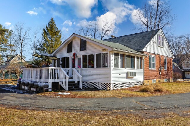 840 Columbus Ave, Stroudsburg, PA 18360 - view of front of house with a sunroom, roof with shingles, a deck, and brick siding