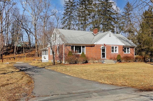 840 Columbus Ave, Stroudsburg, PA 18360 - view of front of house with brick siding, a chimney, a front yard, and asphalt driveway