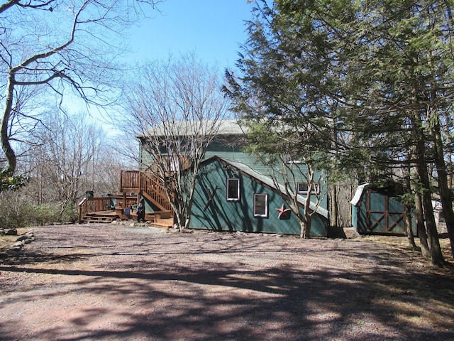 view of side of property with stairway and a deck