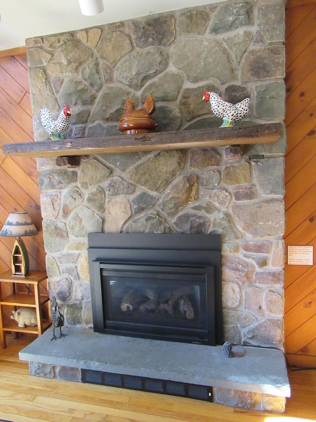 room details with wood walls, a fireplace, and wood finished floors