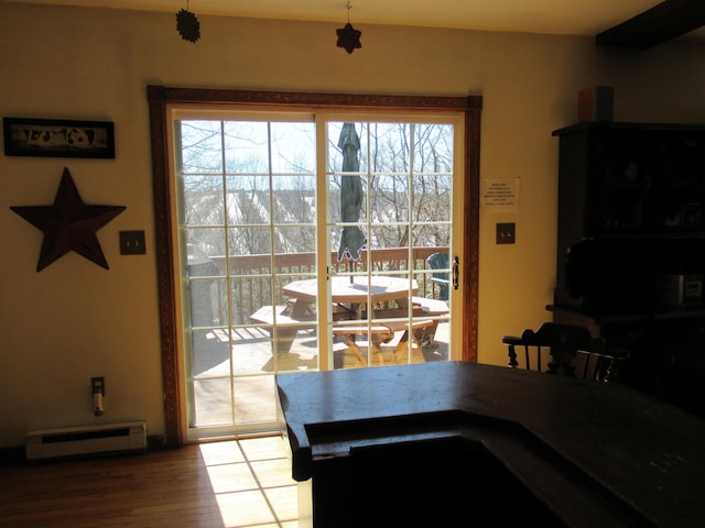 dining space with a baseboard radiator and wood finished floors