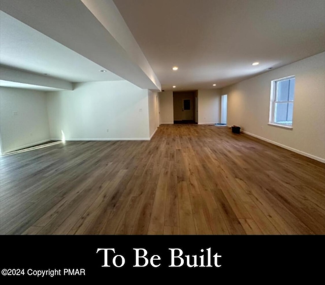 unfurnished living room featuring baseboards, wood finished floors, and recessed lighting