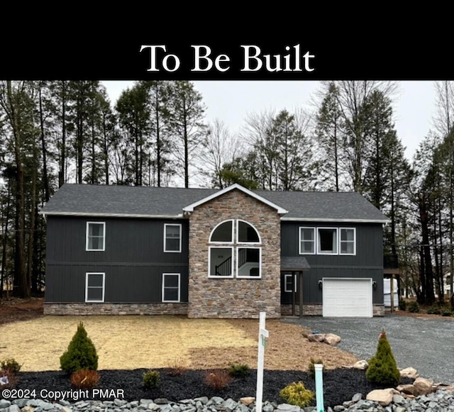 view of front of property with a garage, stone siding, and driveway