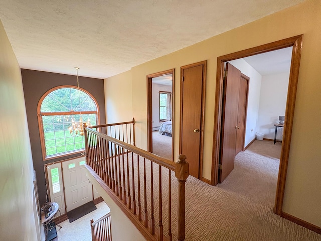 439 Cedar Dr, Long Pond, PA 18334 - hallway with light carpet, a chandelier, an upstairs landing, and baseboards