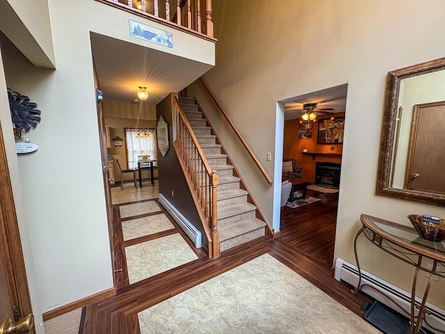 439 Cedar Dr, Long Pond, PA 18334 - stairs with a baseboard radiator, a baseboard heating unit, a ceiling fan, baseboards, and wood finished floors