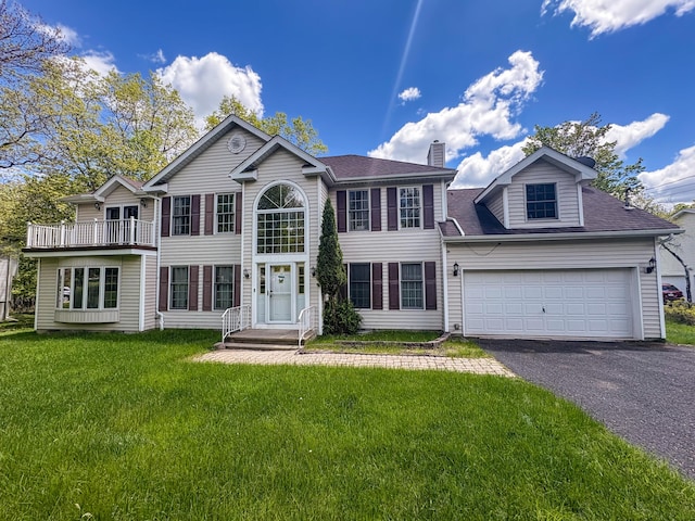 439 Cedar Dr, Long Pond, PA 18334 - colonial house featuring asphalt driveway, a chimney, a front yard, an attached garage, and roof with shingles