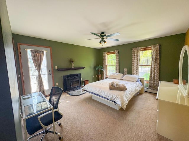 439 Cedar Dr, Long Pond, PA 18334 - bedroom featuring a baseboard radiator, a wood stove, ceiling fan, access to exterior, and carpet
