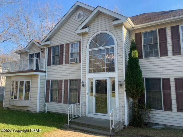 back of house with crawl space and a balcony