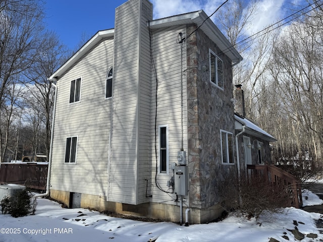 view of snowy exterior with a chimney