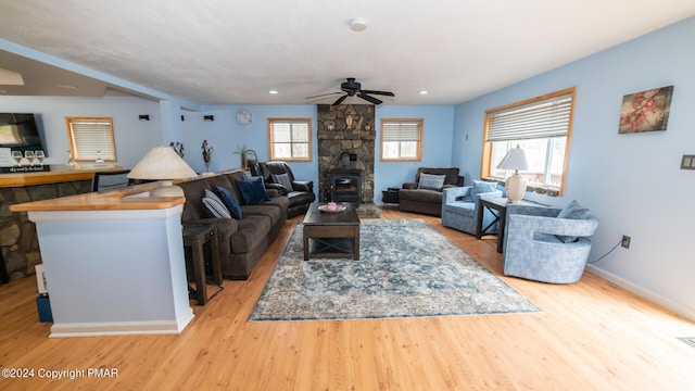 living room featuring a ceiling fan, plenty of natural light, baseboards, and wood finished floors