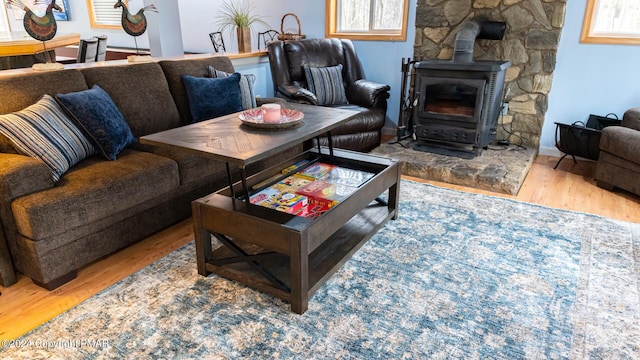 living area with a wood stove and wood finished floors