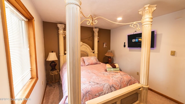 bedroom with carpet, decorative columns, and baseboards