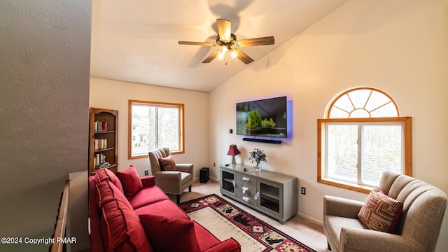 living area with lofted ceiling, ceiling fan, carpet flooring, and baseboards