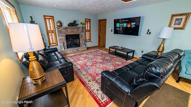 living room with a fireplace, wood-type flooring, and a textured ceiling