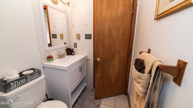 bathroom featuring vanity, tile patterned flooring, toilet, and tile walls