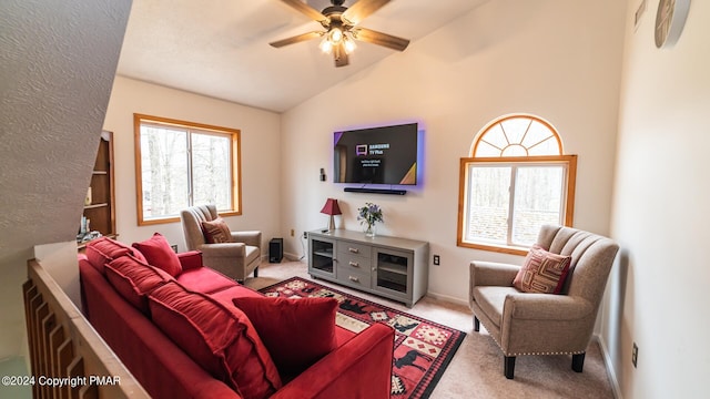 living room with lofted ceiling, a ceiling fan, and carpet flooring