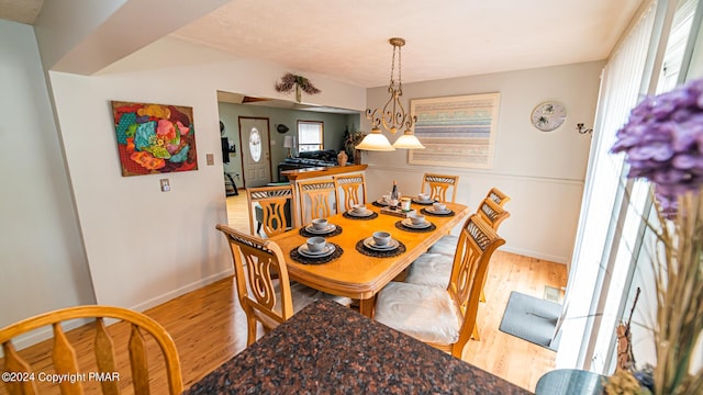 dining space featuring baseboards and light wood finished floors