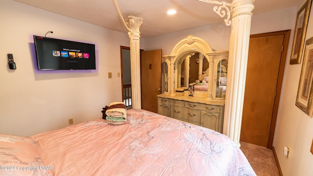 carpeted bedroom featuring ornate columns