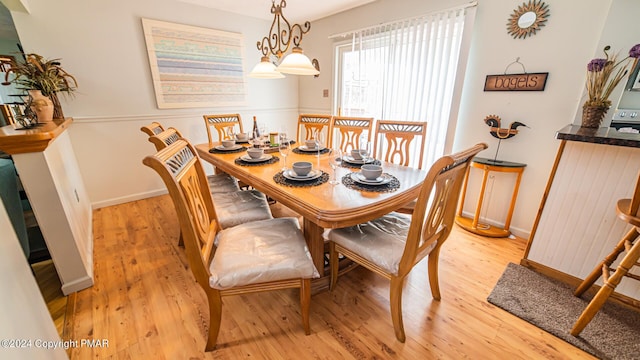 dining area featuring light wood-style flooring and baseboards