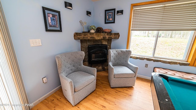 living area with light wood-style floors, a fireplace, and baseboards