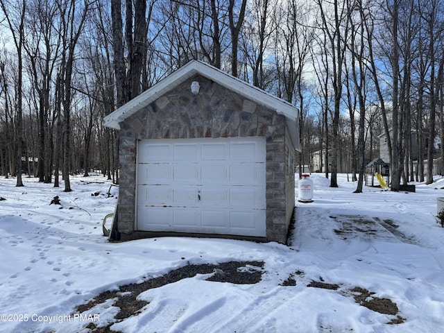 snow covered garage featuring a garage