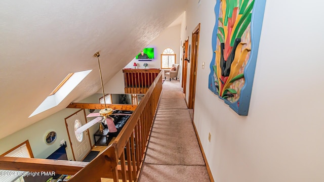 stairway with lofted ceiling with skylight and carpet floors