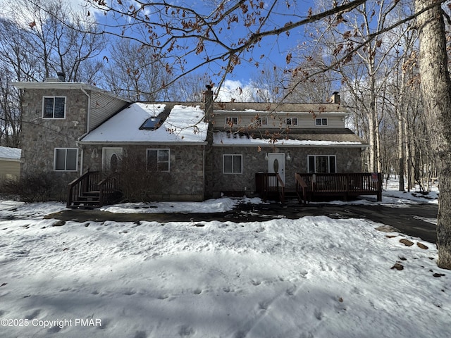 snow covered house featuring a deck