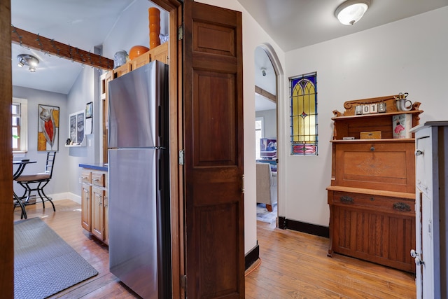 927 Hickory Valley Rd, Stroudsburg, PA 18360 - kitchen featuring freestanding refrigerator, arched walkways, light wood-style floors, and baseboards