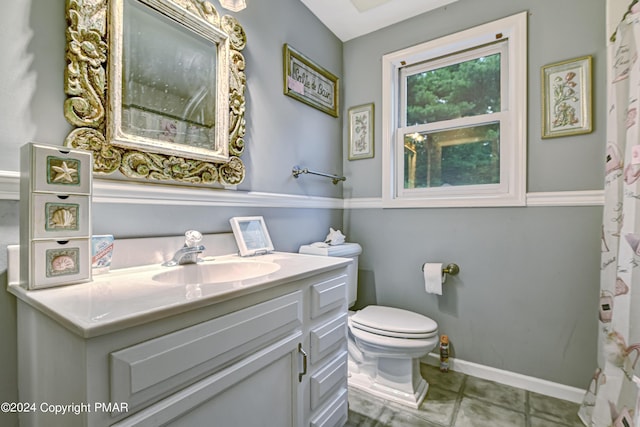 bathroom featuring tile patterned flooring, vanity, toilet, and baseboards