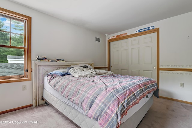 bedroom featuring light carpet, a closet, visible vents, and baseboards