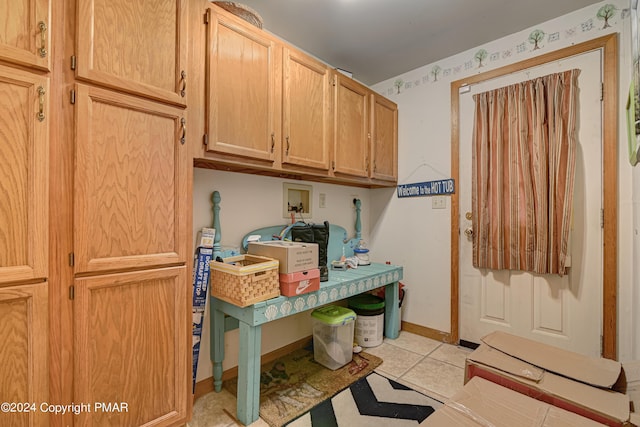 laundry area featuring light tile patterned floors, washer hookup, cabinet space, and baseboards