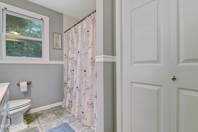 bathroom featuring baseboards, a shower with shower curtain, toilet, tile patterned flooring, and vanity