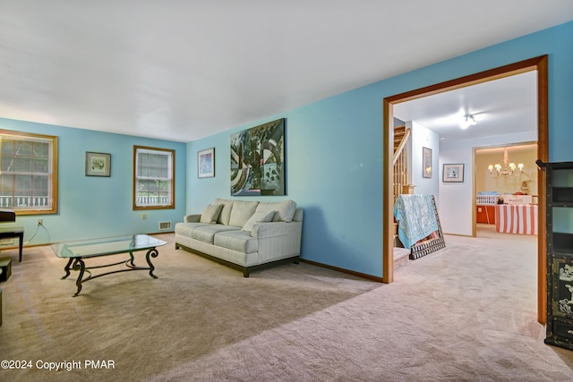 living area featuring baseboards, visible vents, stairs, carpet flooring, and a notable chandelier