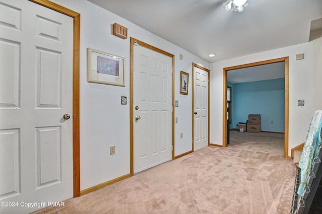 interior space featuring light colored carpet and baseboards