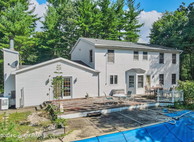 back of house featuring a chimney, a wooden deck, and central air condition unit