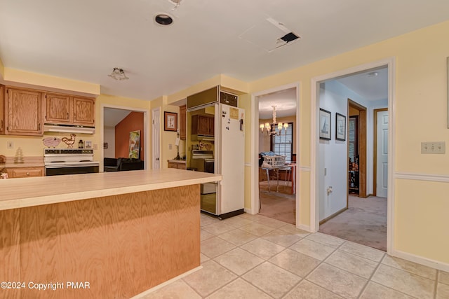 kitchen with electric stove, light countertops, an inviting chandelier, light tile patterned flooring, and under cabinet range hood