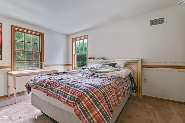 bedroom featuring baseboards, visible vents, and light colored carpet