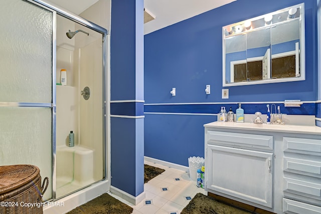 bathroom with baseboards, a shower stall, vanity, and tile patterned floors