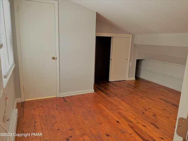 bonus room with baseboards, vaulted ceiling, and hardwood / wood-style floors