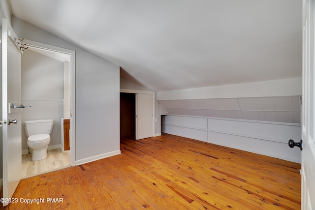 bonus room featuring lofted ceiling, light wood finished floors, and baseboards