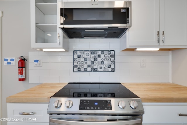 kitchen featuring extractor fan, stainless steel appliances, butcher block countertops, white cabinetry, and glass insert cabinets