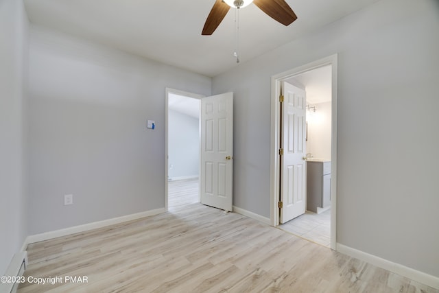 unfurnished bedroom with baseboards, a ceiling fan, wood finished floors, ensuite bathroom, and a baseboard heating unit