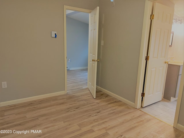 unfurnished room featuring light wood-type flooring and baseboards